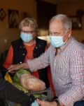 Young woman delivering groceries to an elderly couple wearing face masks