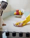Cropped shot of a woman cleaning a kitchen counter at home.