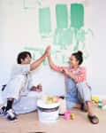 Happy couple giving high-five while taking break from home renovation