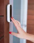 Woman Ringing Front Doorbell Equipped With Security Video Camera