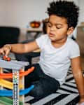 Young boy playing with toy blocks in living room