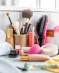 messy vanity with makeup brushes, makeup wipes, and clutter