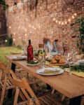 Table ready for dinner party in back yard on a summer evening