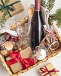 Refined Christmas gift basket for culinary enthusiats with bottle of wine and mulled wine ingredients. Corporate hamper or personal present for cooking lovers, foodies and gourmands.