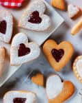 Top view of traditional heart-shaped Linzer cookies with raspberry jam.