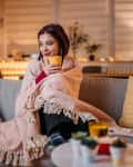 woman drinking hot tea wrapped in blanket