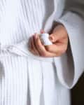 Woman bathrobe after shower in white clean bathrobe. Terry bath warm bathrobe concept