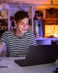 Student at home doing school project late at night on computer/laptop
