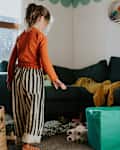 A little girl in a untidy playroom