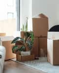 Stacking of cardboard boxes in the living while moving house. House moving service. New home owner.