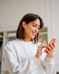 Woman using phone in bedroom.
