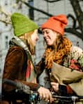 two women laughing holding bouquet of flowers on crisp spring day