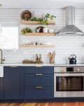 kitchen with open shelving, white tile wall, and blue cabinets/drawers