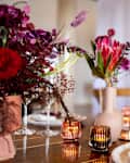 Luxury wedding event table set with flower decorations and candles.