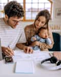 Young family with baby going over finances at home.