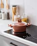 Clean black induction stove with control panel near marble countertop
