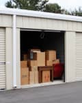 Self storage warehouse with single storage unit open, boxes inside