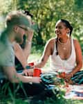 Friends having a picnic on a blanket and drinking from solo cups