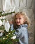 Surprised girl opening Christmas advent calendar near the Christmas tree