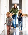 Young girls bringing delivery package into home -