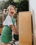 An excited little girl makes a mess in an outside 'mud kitchen'