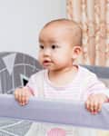 Baby playing in portable crib/pack 'n' play