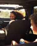 Excited family on a road trip in car, rear passenger POV