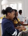Teenage girls having fun whilst washing up in the home