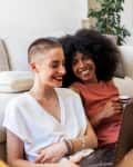2 female friends on a laptop at home