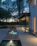 Exterior of a modern house and garden illuminated at night.