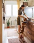 Woman cooking in the kitchen with her dog