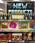 Display of new grocery products featuring wine, pasta, desserts, and a sign directing to frozen items.