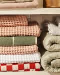different colors and textures of towels, sheets, blankets, folded in linen closet