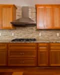 Kitchen with ambered wood cabinets and brown mosaic tile backsplash