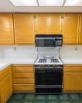 Old condo kitchen with oak cabinets, tile countertops, gas stove and green flooring.  Unchanged since 1988.