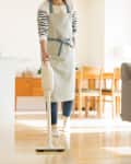 Woman vacuuming kitchen