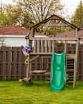 Swing set in backyard during spring season with lush grassy lawn