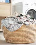 Basket with dirty laundry on floor in bathroom