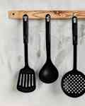 Black kitchen utensils against the background of a light texture wall. Kitchen wallpapers