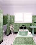 Killara, Sydney, Australia - Feb 12 2021: Green and white art deco tiled bathroom with bath in the center of the room