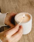 The girl lights a candle at her desk at home. A minute of relaxation after working with a laptop. Relaxation and Zen atmosphere