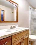 Bathroom interior with cabinet and glass door shower.