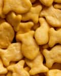 Goldfish cookies background. Closeup view of fish-shaped salted crackers. Small biscuits.