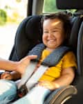 Japanese Mother Ensures Infant Safety In Car Seat, Adjusting Automobile Chair Harness for Toddler Daughter, Cropped Shot. Secure Automobile Journey With Little Baby Concept