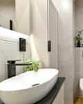 Photo of modern small bathroom with cashmere cabinets, LED-lit mirror, wall-hung toilet and shf modern small bathroom with cashmere cabinets, LED-lit mirror, wall-hung toilet and shower cubicle