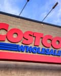 Calgary, Alberta, Canada. March 8, 2026. Exterior of a Costco Wholesale warehouse building featuring the large red and blue brand logo against a blue sky.