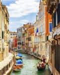 View of the Rio Marin Canal with boats and gondolas from the Ponte de la Bergami in Venice, Italy. Venice is a popular tourist destination of Europe.