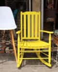 Vintage yellow rocking chair and lamp on street flea market