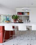 white modern kitchen island bench with high chairs and terrazzo floor