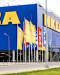 Large blue IKEA store exterior with yellow signage and multiple flags.